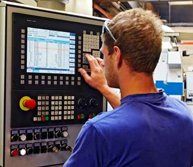 skilled worker controlling a digitally programmed machine tool
